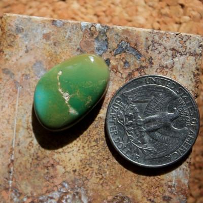 Varying green hues contrast tan matrix on this natural Nevada turquoise cabochon