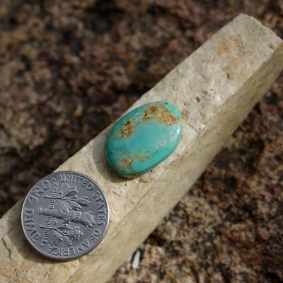 Green contrasts brown on this natural turquoise cabochon