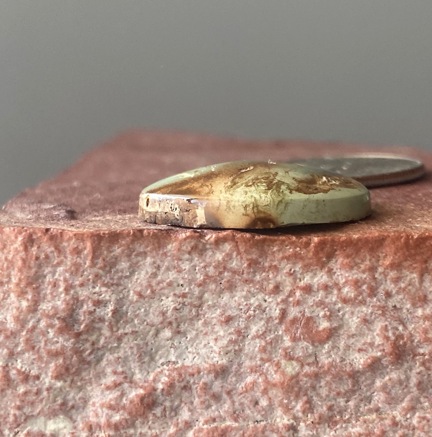 13 carat green Stone Mountain Turquoise cabochon with red inclusions