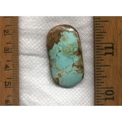 A blue turquoise cabochon with red matrix designed by the Nevada Cassidys